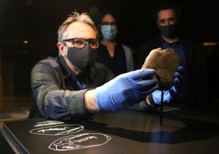 El conservador de les col·leccions de prehistòria del Museu d’Arqueologia de Catalunya, Antoni Palomo, col·loca la placa de pedra de finals del Paleolític Superior descoberta recentment