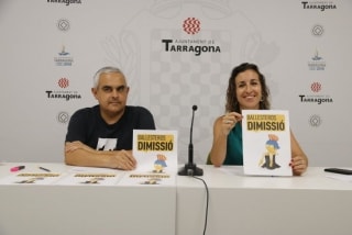 Els regidors de la CUP, Laia Estrada i Jordi Martí, amb un cartell amb la mascota dels Jocs Mediterranis, Tàrracus, que demana la dimissió de l&#039;alcalde Ballesteros