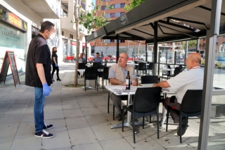 Imatge del propietari del bar restaurant Casa Matías de Tarragona enraonant amb els primers clients que té a la terrasa amb motiu del pas a la fase 1