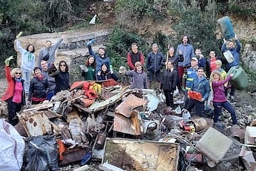 Imatge dels participants en la recollida de residus a la Vall del riu Brugent amb les deixalles retirades