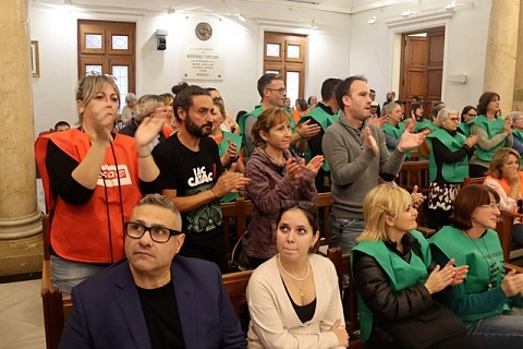 Treballadors, usuaris i familiars de la Residència de Gent Gran de Reus aplaudint l'aprovació de la proposta de declaració de suspensió del tancament de l'equipament durant el plenari 