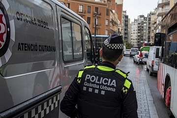 Un agent de la Guàrdia Urbana de Tarragona al costat d'una oficina mòbil