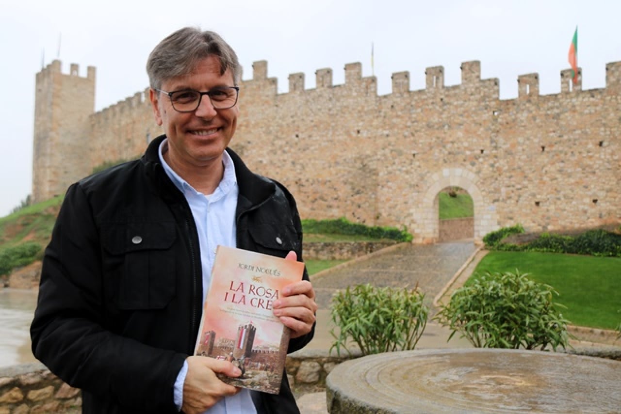 L&#039;escriptor Jordi Nogués subjectant la seva nova novel·la &#039;La rosa i la creu&#039; davant les muralles de Montblanc