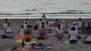 Imatge d&#039;una sessió de ioga efectuada a la platja de la Pineda.