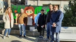 El conseller de Comerç, Dídac Nadal, i la representant de la Via T, Judit Sentís, amb artistes de l’Associació d’Il·lustradors de Tarragona (DINAMU), al davant d&#039;un mural de Marta Escobar, a la Rambla Nova