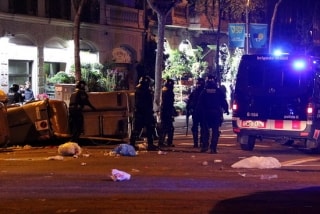 Agents antidisturbis dels Mossos d&#039;Esquadra retirant contenidors tombats al mig del carrer a Barcelona durant els aldarulls posteriors a la manifestació del 25 de març