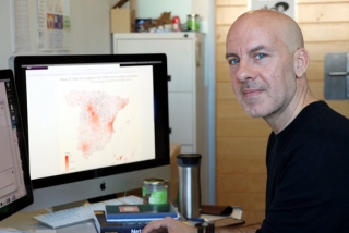Àlex Arenas, investigador del grup de recerca Alephsys Lab de la URV, amb una pantalla al fons amb el mapa de l&#039;estat espanyol