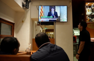 Clients d&#039;un bar escolten la declaració institucional de Carles Puigdemont per la televisió, ahir a la nit