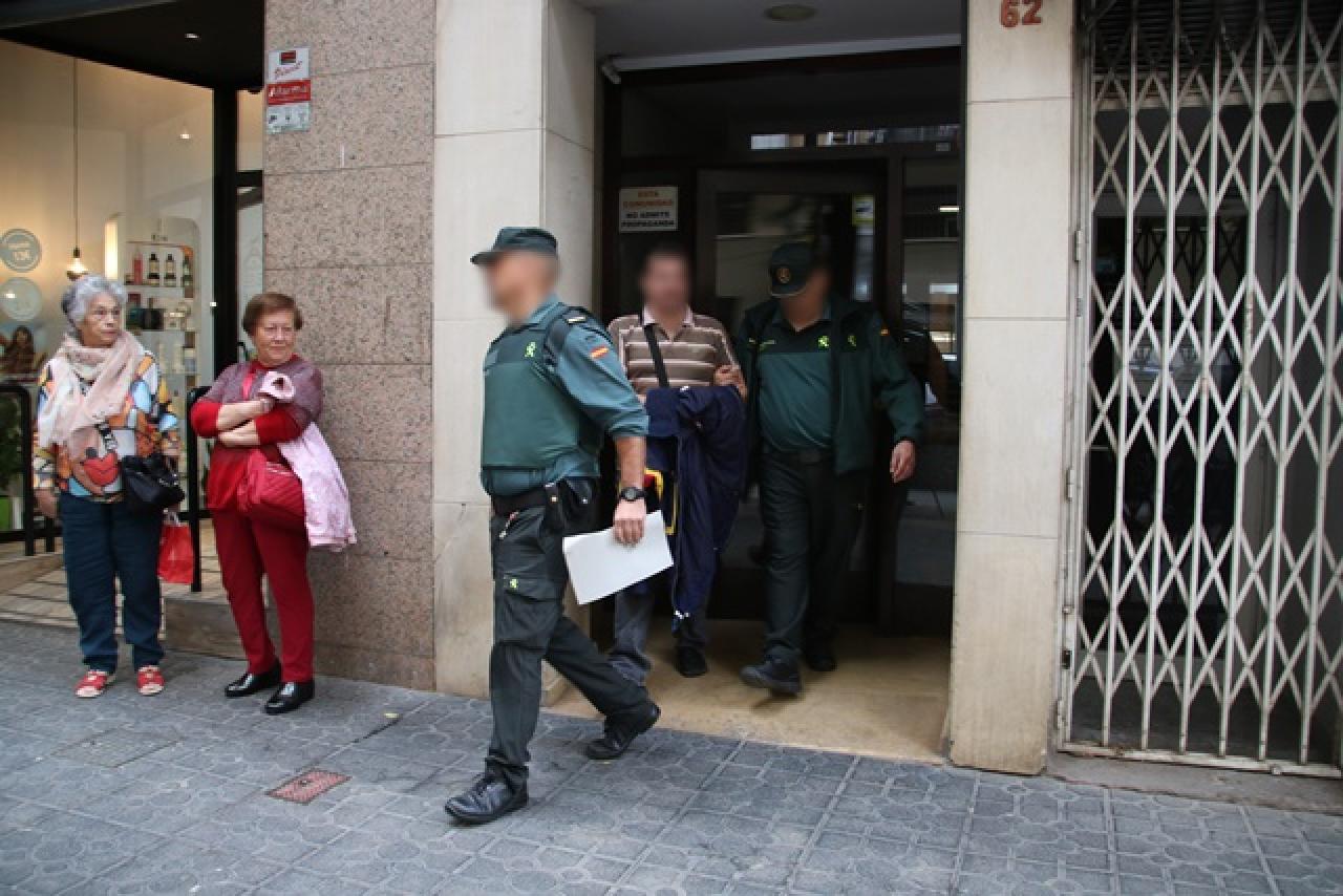 Dos agents de la Guàrdia Civil sortint amb un detingut en un dels registres fets a Tarragona l&#039;operatiu policial conjunt amb els Mossos d&#039;Esquadra