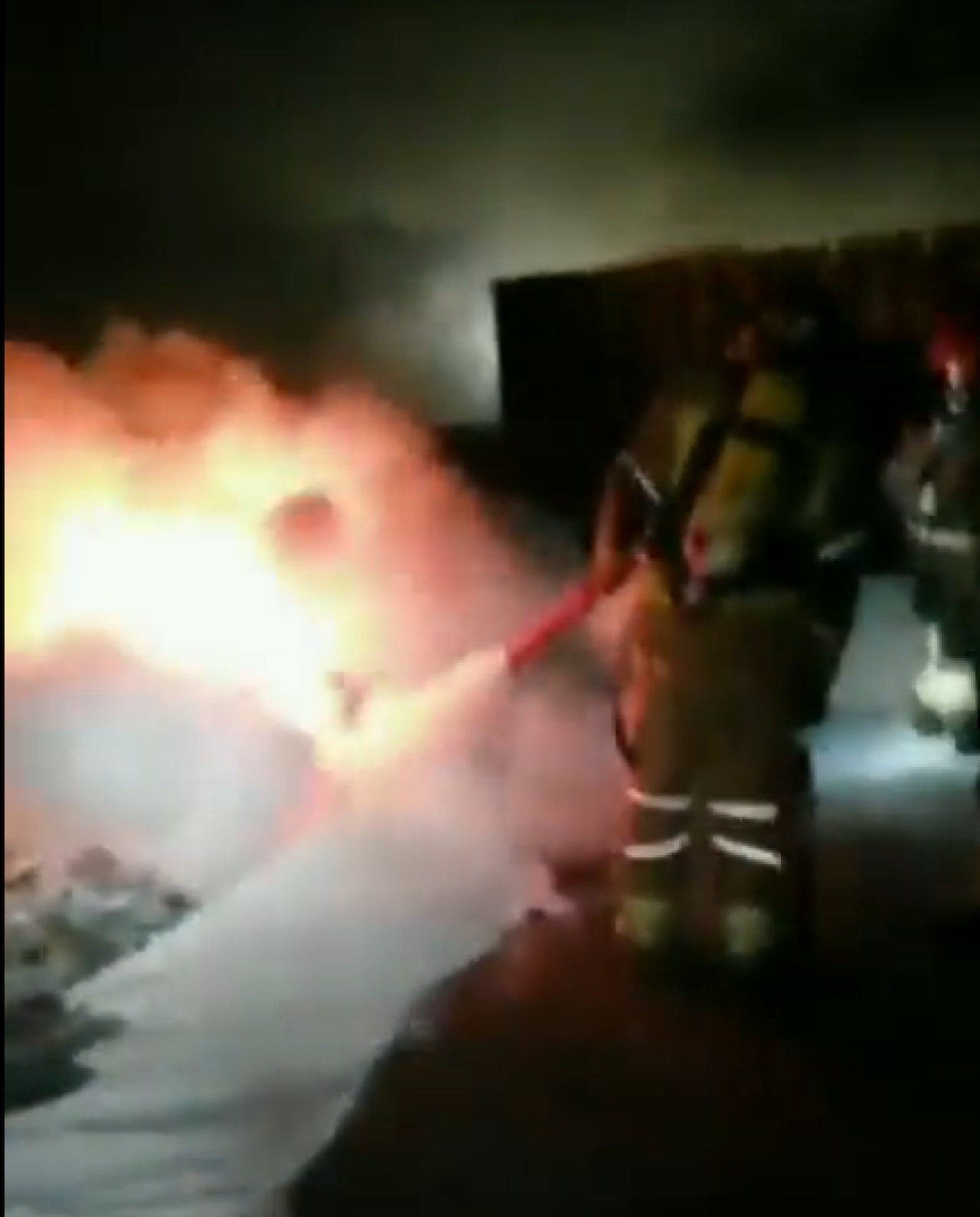 El bombers treballant aquesta matinada en un foc que afectava sacs de clorur de calci, a l&#039;exterior de la nau