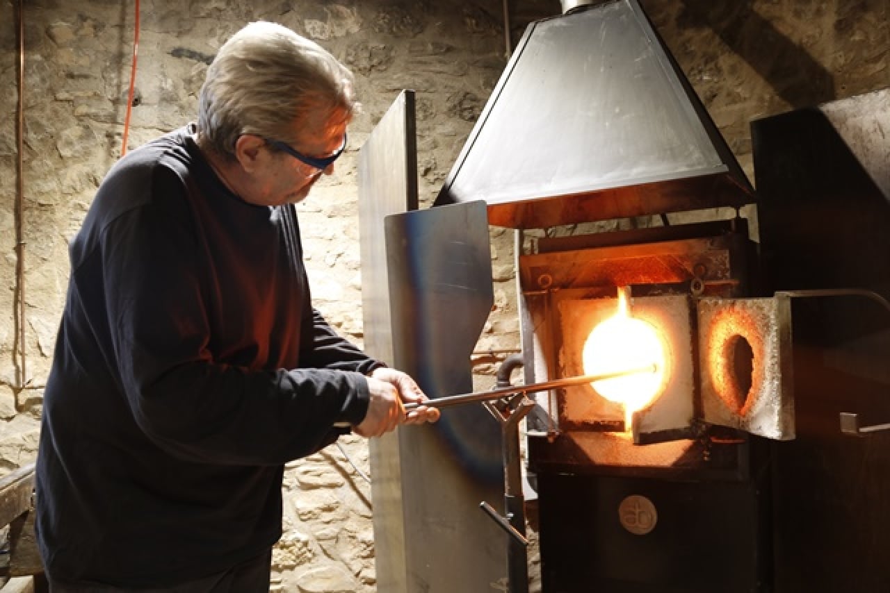El mestre vidrier del Museu del Vidre de Vimbodí i Poblet, Paco Ramos, mentre elabora un porró i l&#039;introdueix al forn per reescalfar la peça a les portes de la seva jubilació, en una imatge d&#039;arxiu