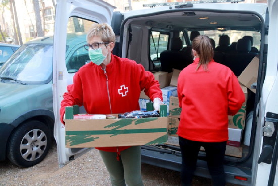 Imatge de dos membres de Creu Roja Tarragona treient els aliments de la furgoneta per pujar-los al domicili d&#039;una persona gran, al barri de Sant Salvador