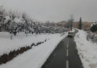 Un vehicle circulant per una carretera nevada del Priorat restablerta pels equips de la Diputació de Tarragona