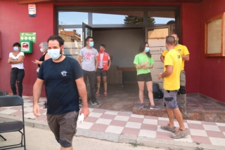 Imatge dels voluntaris a l&#039;entrada de l&#039;Ateneu de Sant Martí de Tous que participen en les tasques per apagar el foc que crema a les comarques de la Conca de Barberà i l&#039;Anoia, el 25 de juliol del 2021