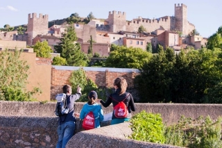 Una família de visitants observa la Muralla de Montblanc