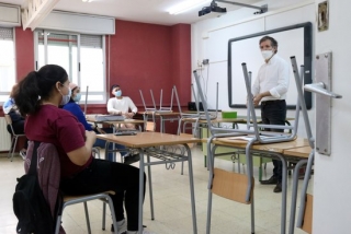 Un professor parlant amb diversos alumnes de segon de batxillerat en una aula d&#039;un centre