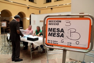 Imatge d&#039;un cartell indicatiu i d&#039;un elector votant en un dels col·legis electorals de la ciutat de Tarragona, el 26 de maig del 2019