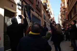 Un home damunt d&#039;una escala mentre retirar una placa franquista dels carrers de Tarragona i la resta dels participants en l&#039;acció