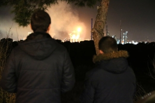 Imatge posterior de dos joves observant la fàbrica sinistrada a la Canonja aquest dimarts al vespre, el 14 de gener de 2020