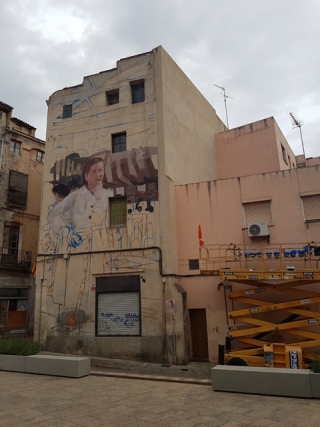 Alba Fabre Sacristán i Antonio Valadés que estan pintant un mural de grans dimensions al carrer Sant Pere (davant la Biblioteca Carles Cardó)