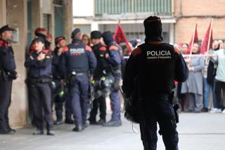 Uns agents dels ARRO mentre s&#039;executa el desnonament a Tarragona amb els manifestants al fons