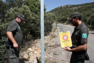 Dos efectius dels Agents Rurals a punt de col·locar un cartell que indica que està prohibit accedir a la serra del Montsec, el 27 de juny de 2019 