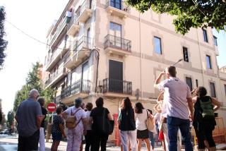 Participants d&#039;esquena observant un dels edificis inclosos en la ruta feta pel carrer Ample de Reus de la iniciativa de Reus Ocult
