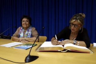 La científica Anna Veiga signant el llibre de la URV al costat de la rectora María José Figueras