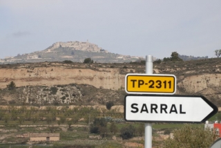 Imatge d&#039;un senyal d&#039;entrada a Sarral (Conca de Barberà) i, al fons dalt d&#039;una muntanya, el poble de Forès, entre els quals es farà una connexió per després bombejar aigua a la resta de municipis