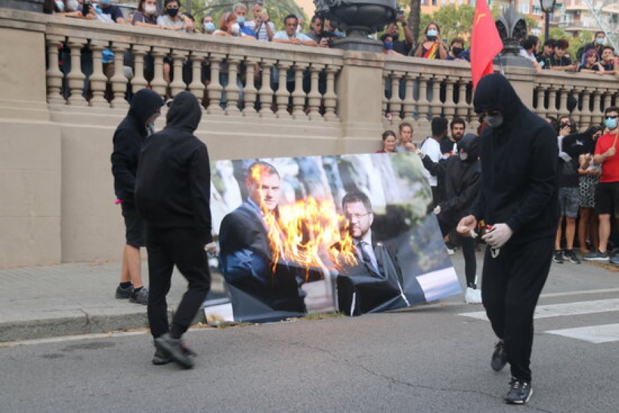 Un grup de manifestants de la marxa convocada per l&#039;esquerra independentista, encaputxats, cremen una foto de grans dimensions amb la imatge de Pedro Sánchez i Pere Aragonès, l&#039;11 de setembre del 2021