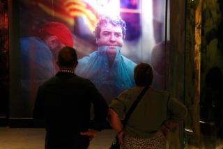 Dos visitants observant un audiovisual del nou Museu Casteller de Catalunya, a Valls