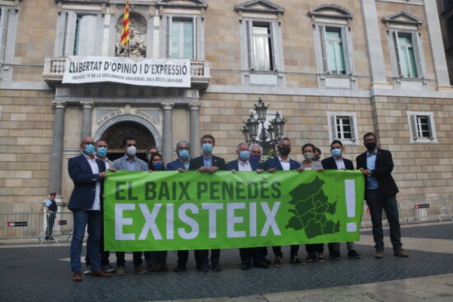 Imatge dels 14 alcaldes i alcaldesses del Baix Penedès mostrant una pancarta davant el Palau de la Generalitat, a la plaça Sant Jaume de Barcelona, on es llegeix &quot;El Baix Penedès existeix&quot;