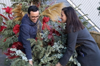 Dues persones col·locant el seu arbre de Nadal en la zona habilitada del Parc Central de Tarragona en el marc de la campanya &quot;Dona una segona vida al teu arbre&quot;