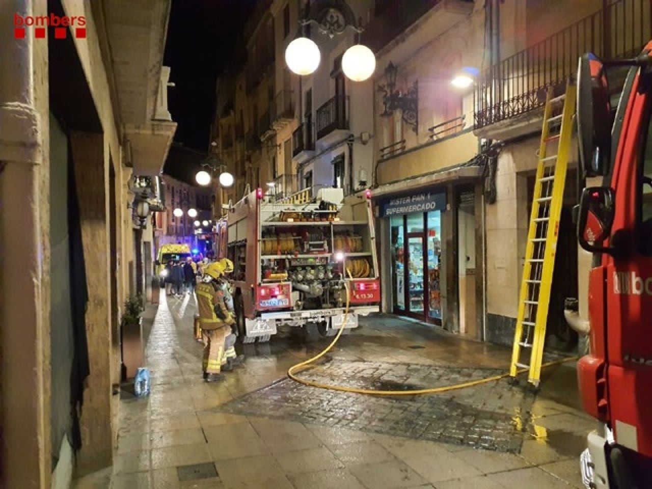 Els bombers treballant en un incendi en un edifici del carrer de la Cort de Valls