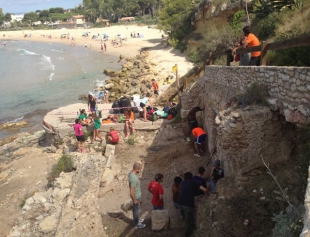 Un grup de joves netegen l&#039;entorn de les Termes de Mar.