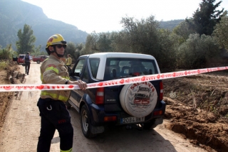 Un bomber deixant passar un vehicle amb el metge forense dins el cordó del dispositiu de rescat a Vilaverd