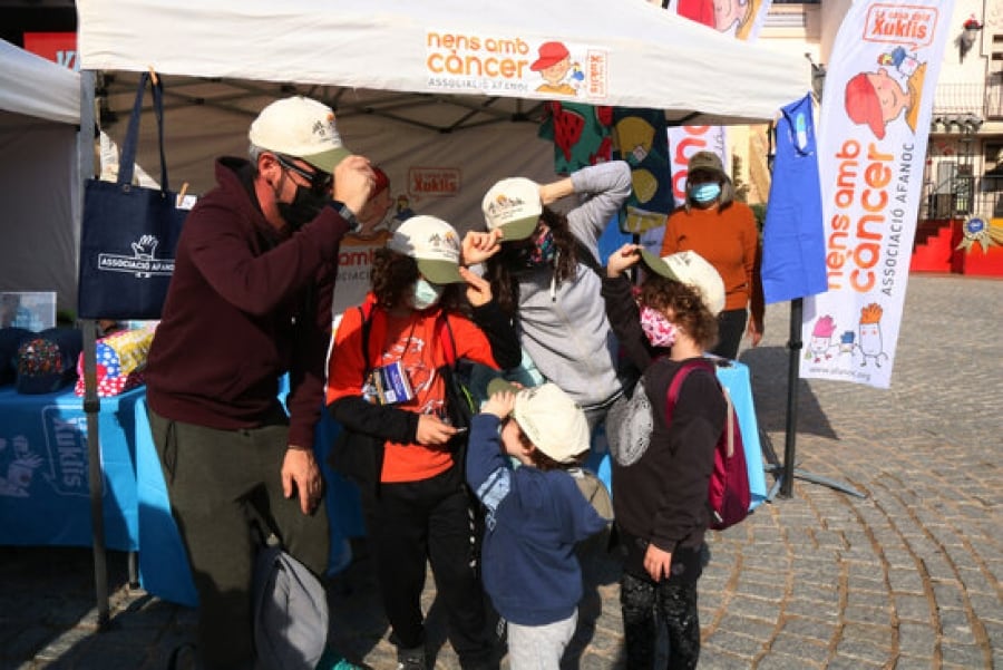 Imatge d’una família posant-se la gorra per participar de la 19a edició de ‘Posa’t la gorra’, organitzada per l’AFANOC a PortAventura World