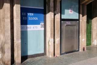 El lateral d&#039;una antiga entitat bancària a Segur de Calafell, actualment tancada i amb un cartell de venda o lloguer