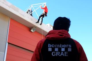Un agent dels GRAE mirant una pràctica de rescat de dos companys de la unitat de Valls