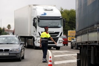 Un agent dels Mossos d&#039;Esquadra aturant un camió a l&#039;N-340, a l&#039;alçada de Roda de Berà, al Baix Gaià, per on no hauria de circular