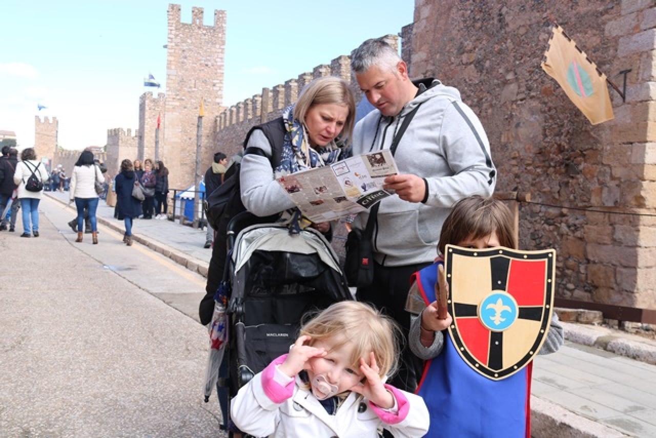 Una família amb un plànol visitant Montblanc durant la Setmana Medieval de la Llegenda de Sant Jordi