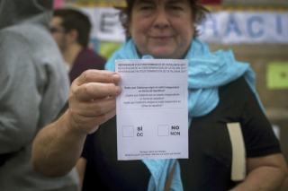 Una dona mostra una papereta del referèndum, en una escola de Barcelona