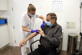 Un home posant-se la vacuna contra la grip