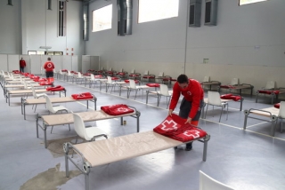Un tècnic de Creu Roja preparant els llits de l&#039;albert muntat al Recinte Firal de Tarragona