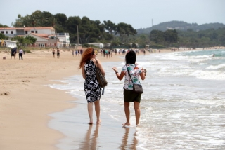 Dues dones d&#039;esquenes caminant a la platja Llarga de Tarragona en l&#039;últim dia de la fase 1