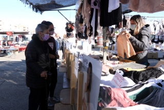 Imatge de dues compradores i d&#039;una venedora ambulant en una parada del mercat de Bonavista en el segon cap de setmana de confinament municipal, el 8 de novembre del 2020