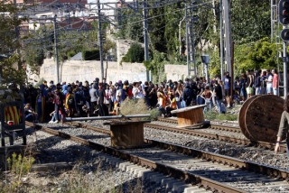 Imatge de les vies del tren entre Tarragona i Reus, amb desenes de manifestants situats al mig, prop del pas a nivell proper a l&#039;escola Joan Rebull