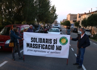 Imatge dels manifestants subjectant una pancarta durant el tall de carretera per denunciar la massificació eòlica i fotovoltaica que pateixen els municipis de l’Urgell i la Conca de Barberà, el 25 de setembre del 2021