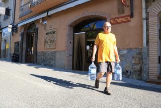 En Joan, veí de la Vilella Baixa, carrega dues garrafes per evitar l&#039;ús de boca de l&#039;aigua de l&#039;aixeta