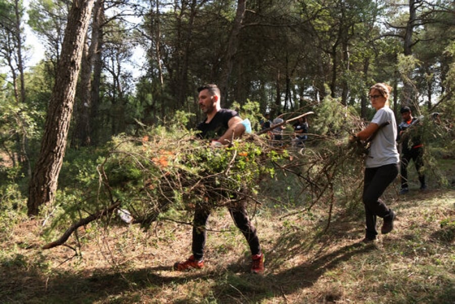 Imatge de voluntaris netejant el bosc en l’acció organitzada per la plataforma Revifem Queralt al terme municipal d’Argençola (Anoia), el 25 de setembre del 2021